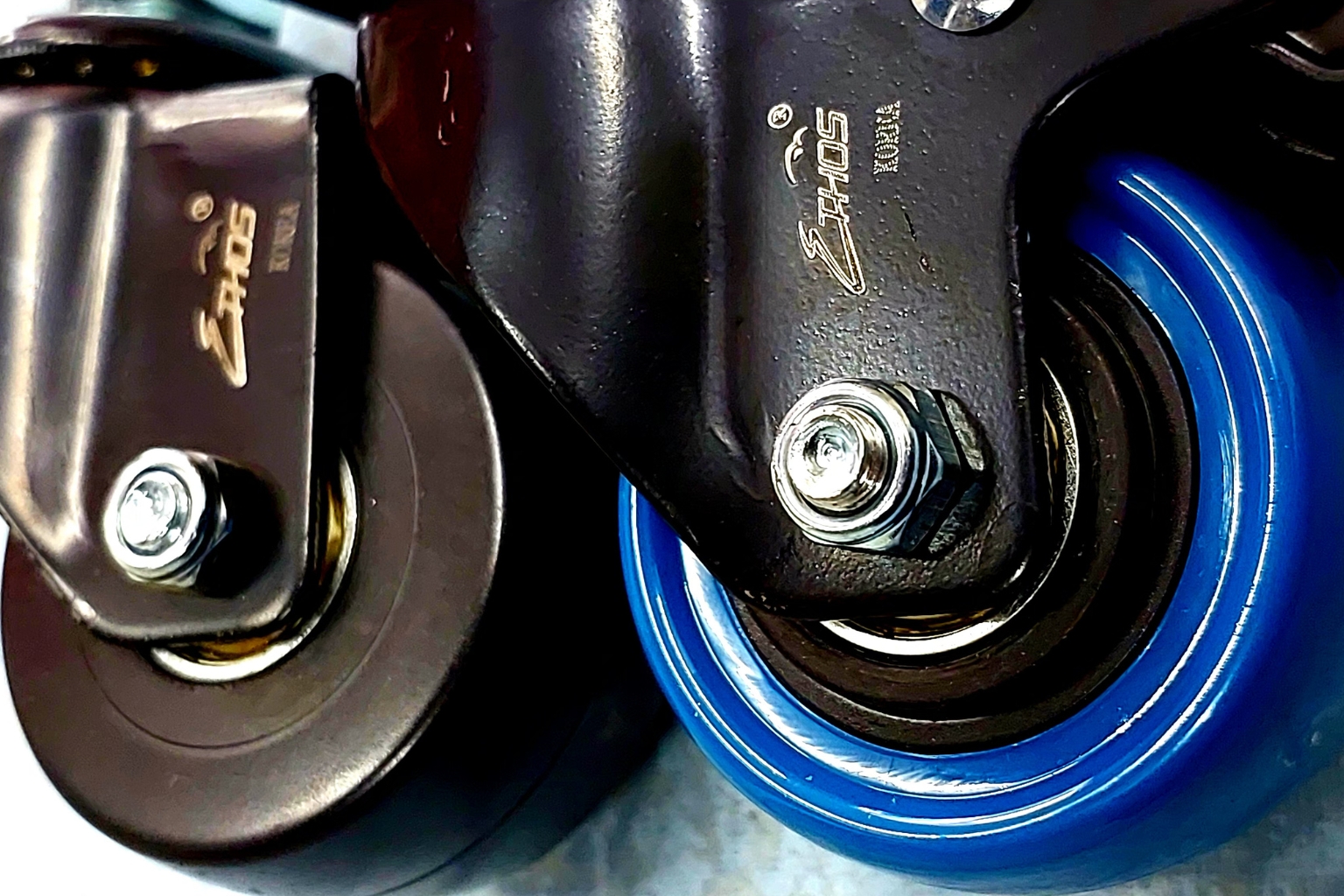 ล้อยูรีเทนสีน้ำเงินและล้อไนล่อนสีดำของแบรนด์ ETHOS วางเปรียบเทียบคู่กัน